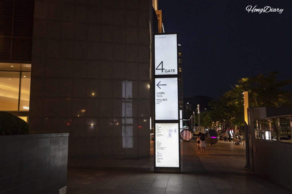 Walking from Centum City Station Exit 12 toward the Spa Land entrance at Shinsegae Department Store in Busan