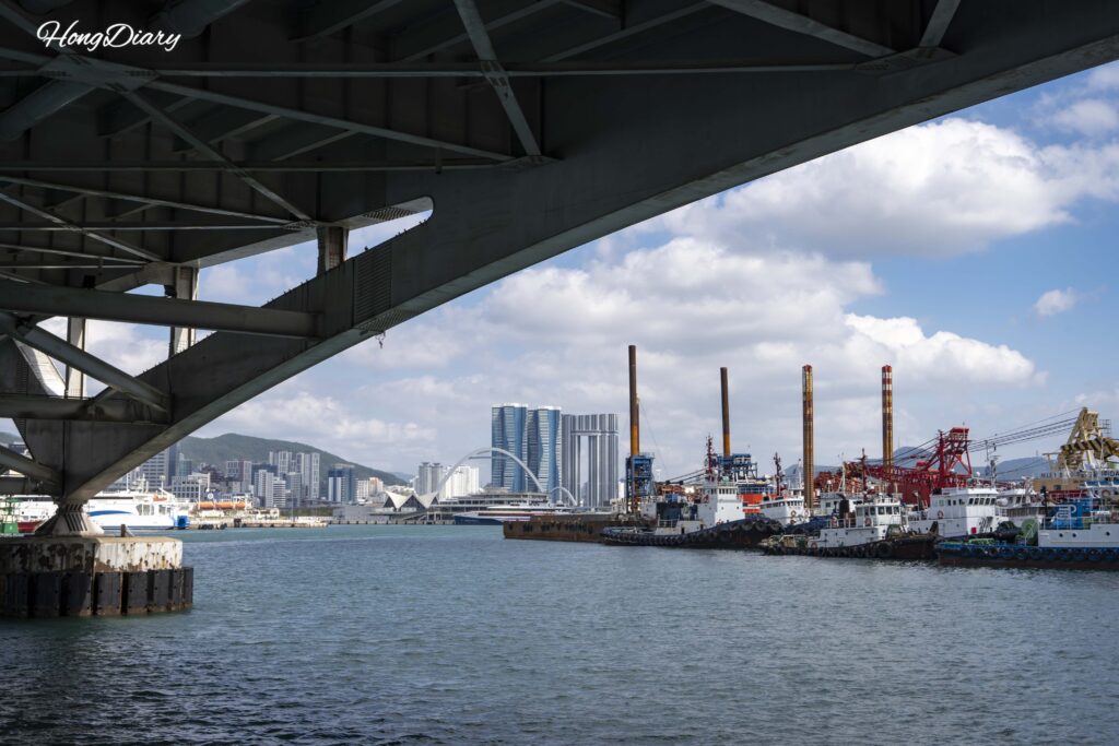 Vista desde debajo del Puente Yeongdo mostrando botes pesqueros, el puerto y el horizonte de Busan