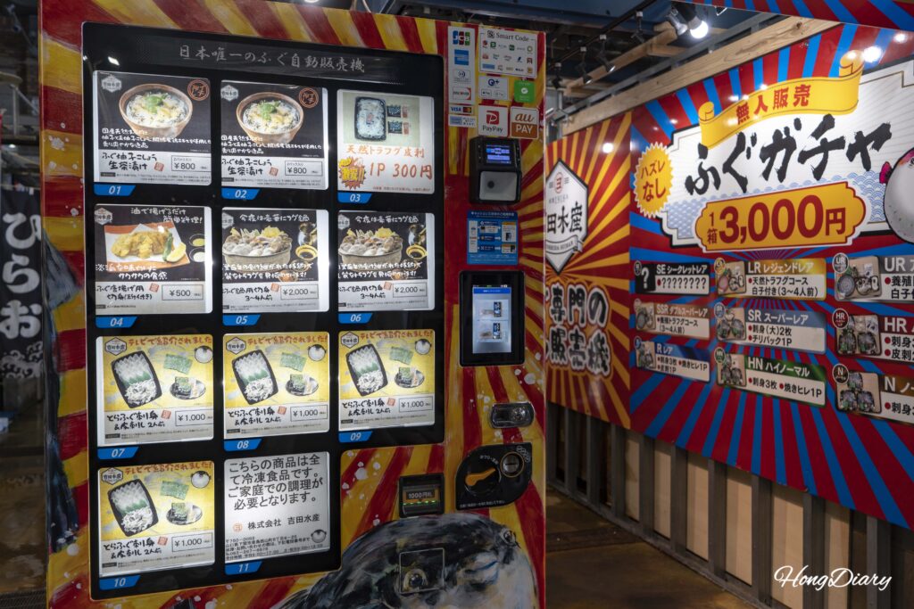 Fugu product vending machine operated by Yoshida Suisan at Karato Market in Shimonoseki, with items priced from 300 to 2000 yen