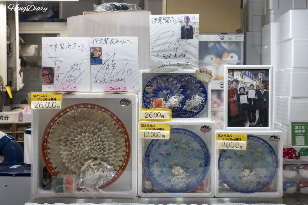 唐戸市場のふぐ刺し専門店、壁一面の芸能人サインとふぐ刺し盛り合わせの見本