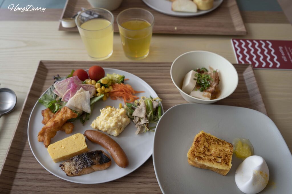 PUKU PUKU朝食で筆者が盛り付けた一皿——サラダ、ソーセージ、焼き魚、たまご焼き、海鮮丼、冷やっこ、フレンチトースト