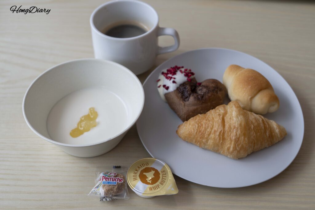 Croissant and bread with Hokkaido butter, coffee, and yogurt at the PUKU PUKU breakfast buffet