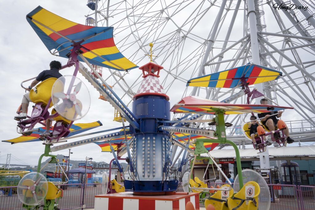 Padre e hijo montados en la atracción Magic Bike de Haikara't Yokocho en Shimonoseki
