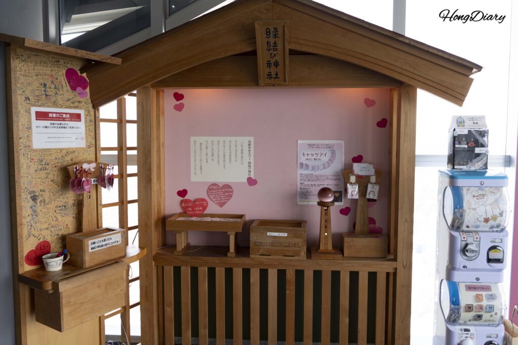 Enmusubi Shrine love-themed display on the 28th floor of Kaikyo Yume Tower with handwritten romantic wishes and messages hanging on a rack