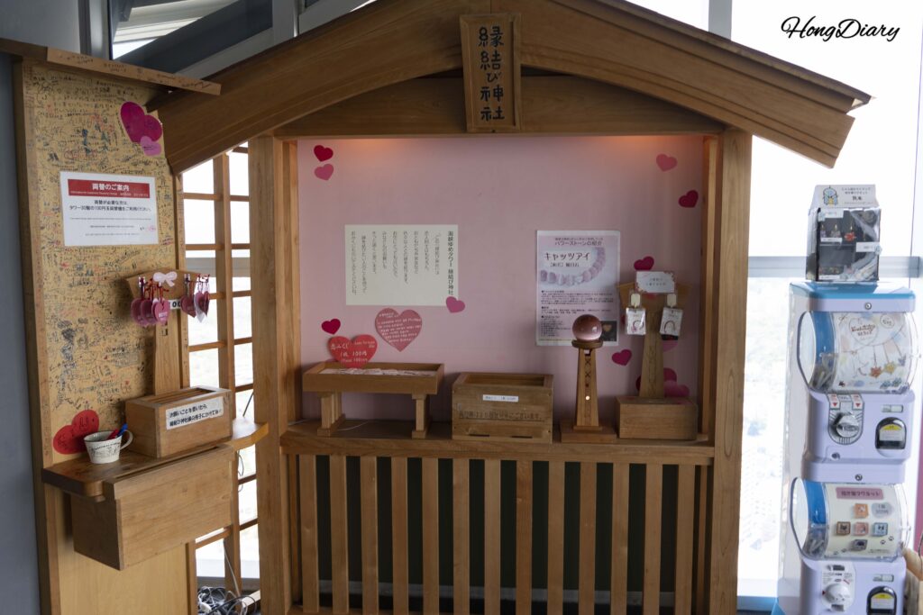 Instalación del Enmusubi Shrine en el piso 28 de Kaikyo Yume Tower con deseos románticos escritos a mano colgados en un expositor