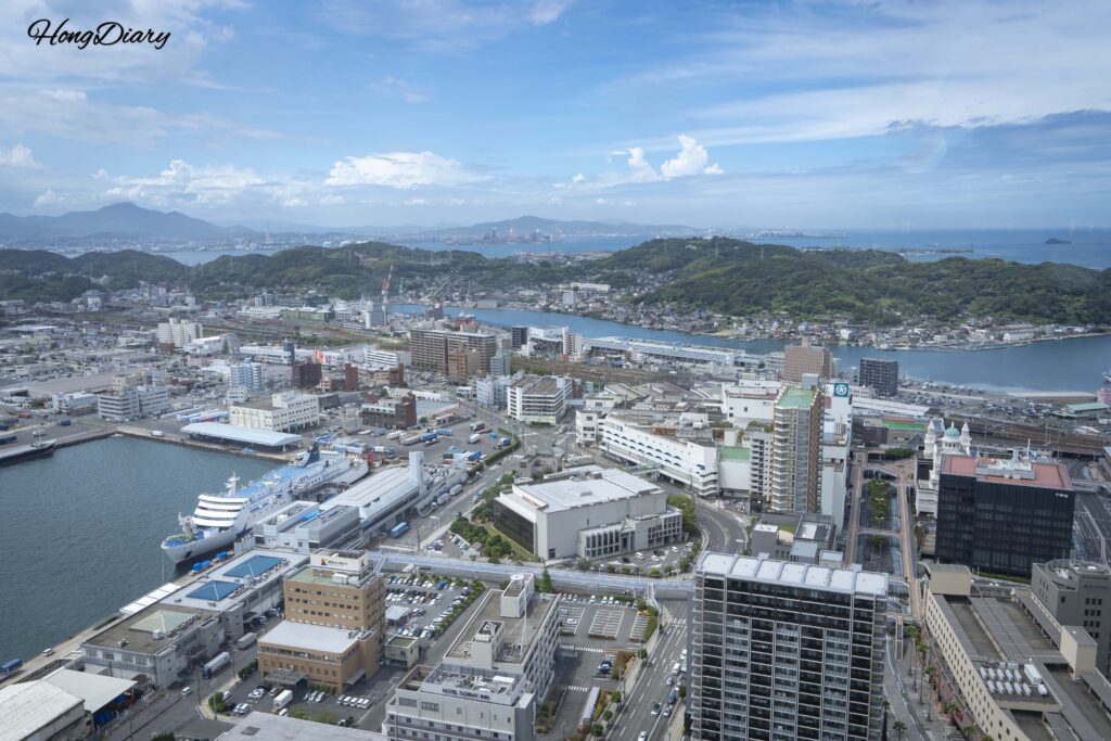 海峡ゆめタワーから西を望む関釜フェリー・下関港国際ターミナル・下関駅・線路と午後の海面