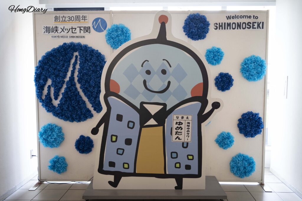 Zona de fotos con la mascota Yume-tan junto a la entrada del ascensor hacia el mirador de Kaikyo Yume Tower