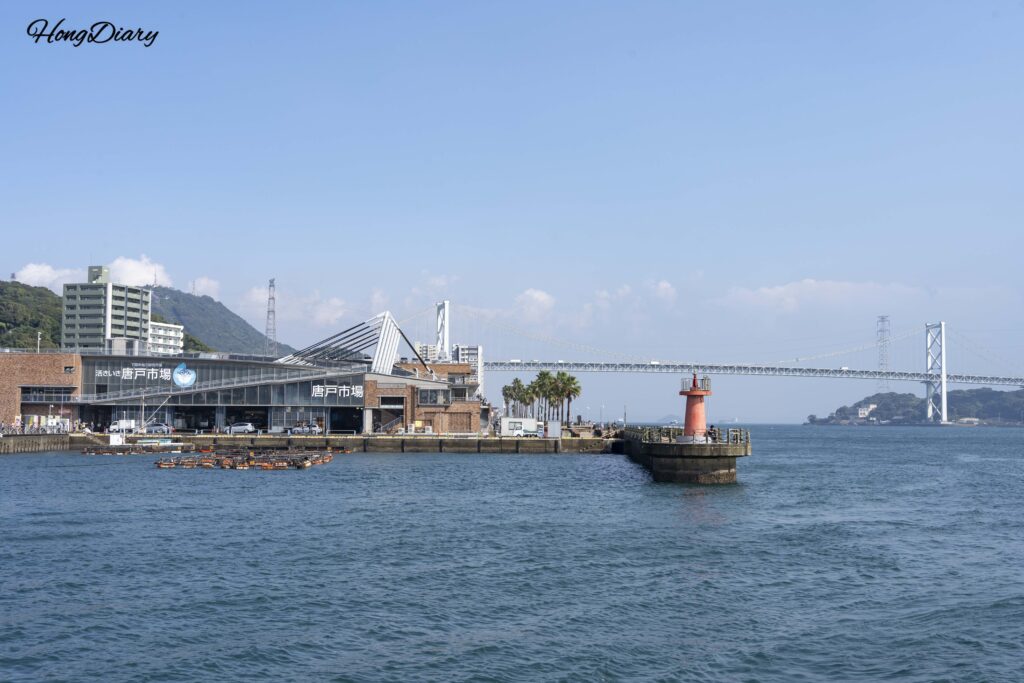 Vista desde el área del acuario Kaikyokan en Shimonoseki, con el océano, el Mercado Karato a lo lejos y el puente Kanmon al fondo