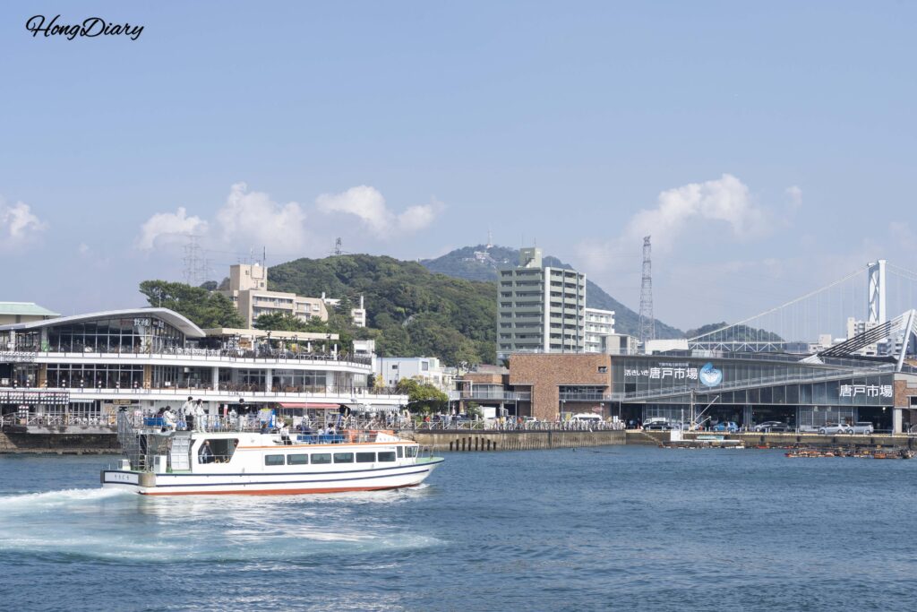 海響館前から望む関門海峡、遠方に唐戸市場と関門橋、門司港を往復するフェリー