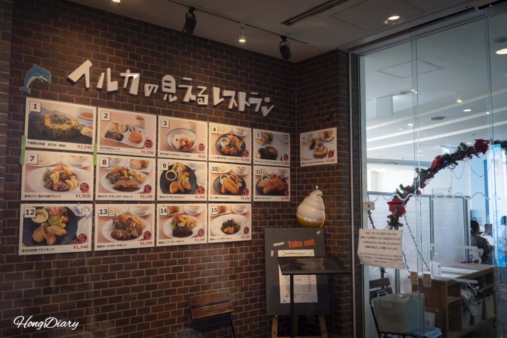 海響館のレストラン入口とメニュー表。お子様カレーからフグの唐揚げまで価格が掲示されている