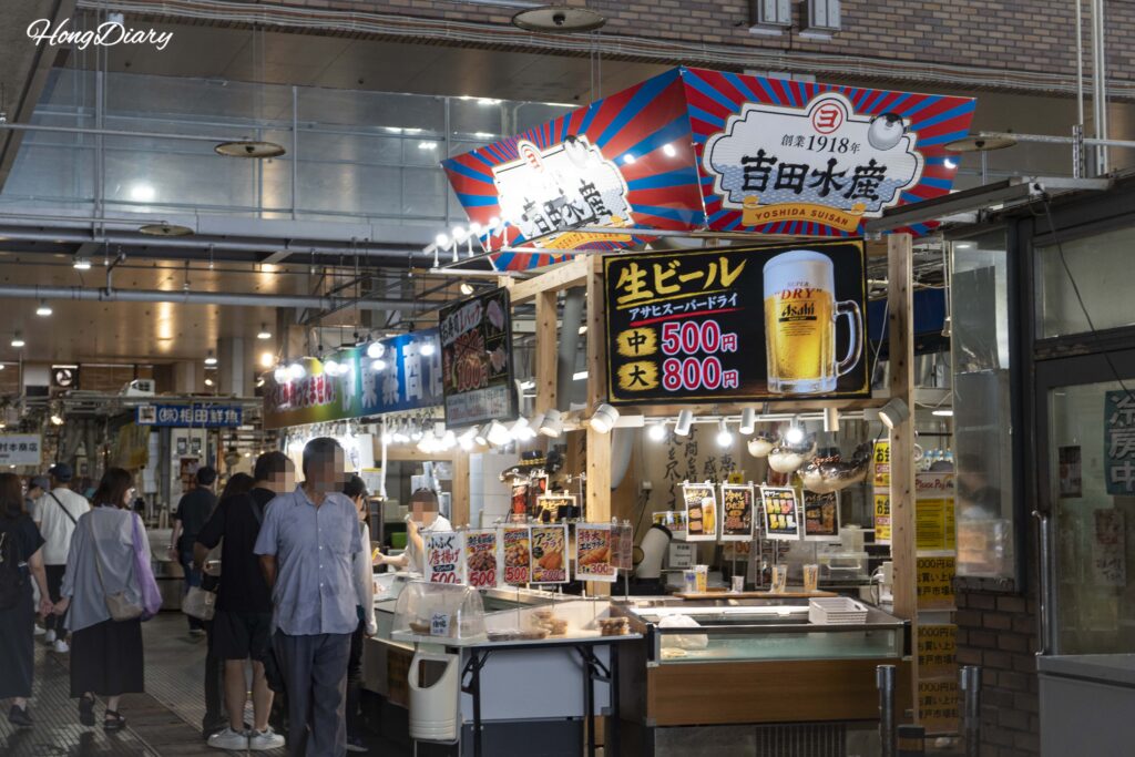Un puesto en el Mercado Karato que vende cerveza Asahi de barril y distintos fritos, con el vaso mediano a 500 yenes y el grande a 800