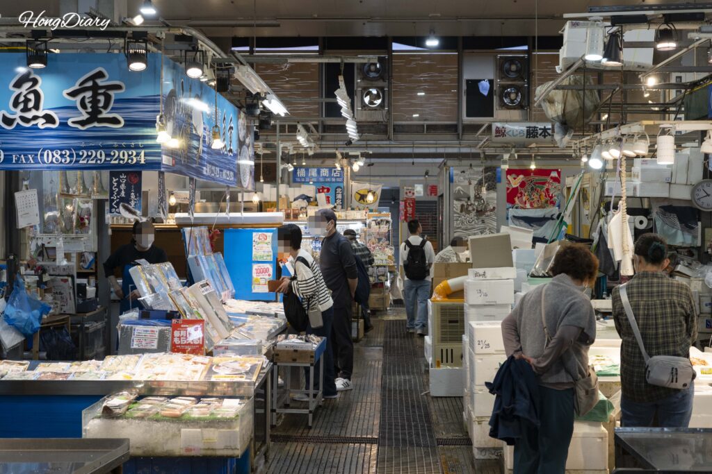 唐戸市場の中ほどにある海産物・加工品の販売店舗と買い物客