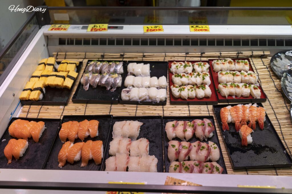 Piezas de sushi económicas en el Mercado Karato: salmón, tamago y jurel entre 100 y 200 yenes cada una