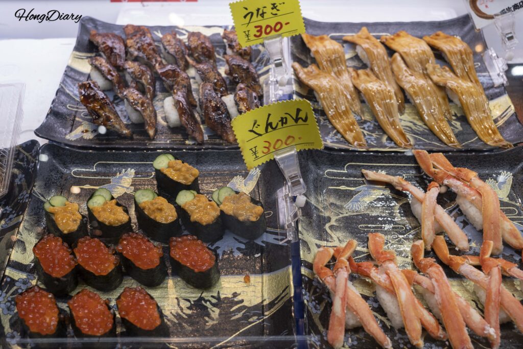 唐戸市場で販売されているイクラ、穴子、ズワイガニなどの握り寿司、1貫300円