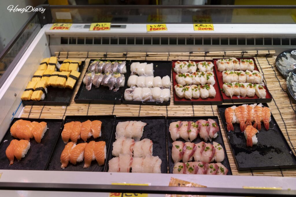 唐戸市場の寿司ケースに並ぶたまご、サーモン、ヒラメなど100～150円の握り寿司