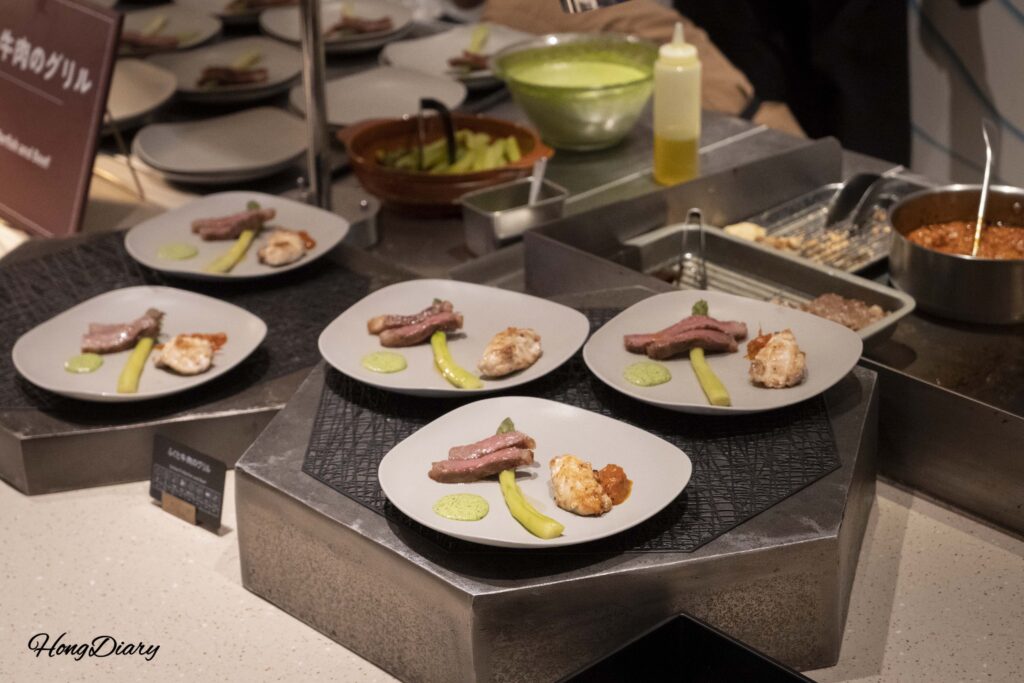 Wagyu steak, grilled fugu, and asparagus at the live grill station in PUKU PUKU