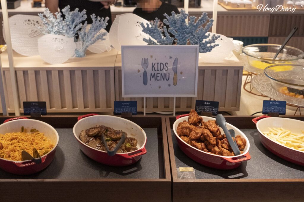 Sección de menú infantil con espagueti, hambāgu y karaage junto a una decoración de fugu de papel en PUKU PUKU