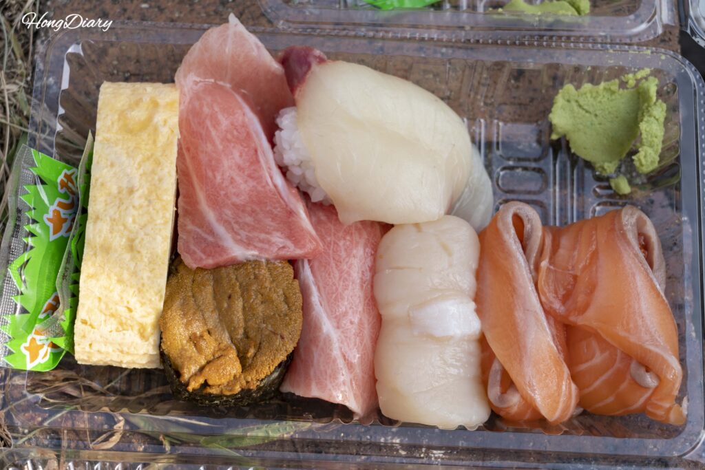 Bandeja de plástico con sushi variado comprado en el Mercado Karato: atún, vieira, salmón, erizo de mar y camarón