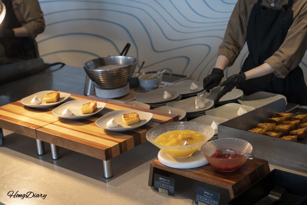 PUKU PUKU朝食のなつみかんフレンチトーストステーション——シェフがクリームを添えて調理中