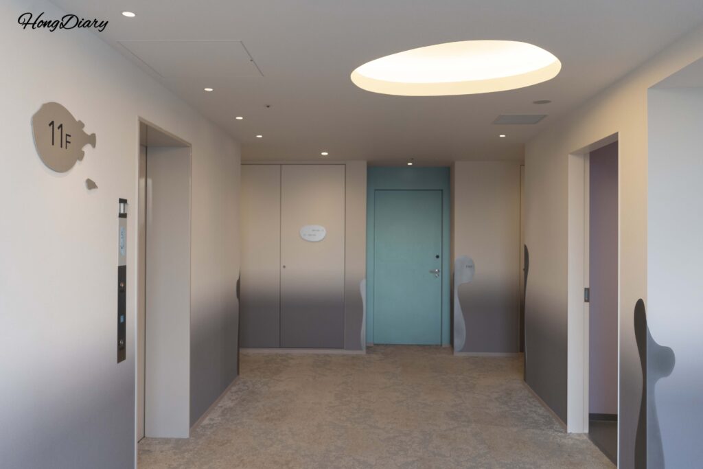 Elevator waiting area on the 11th floor of RISONARE Shimonoseki with a pufferfish-shaped floor number design
