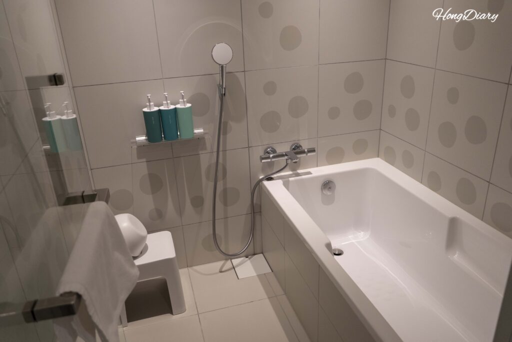 Wet zone bathroom at RISONARE Shimonoseki with a shower area and soaking bathtub, separated from the dry vanity space