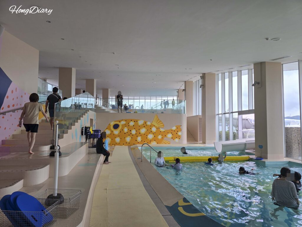 Full overview of the indoor Fugu Pool at RISONARE Shimonoseki featuring colorful pufferfish murals and multiple pool zones