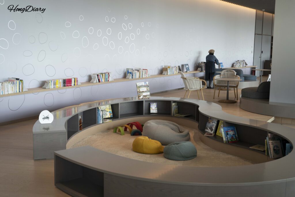 Shoe-free kids' reading nook with picture books at RISONARE Shimonoseki where children can sit and relax