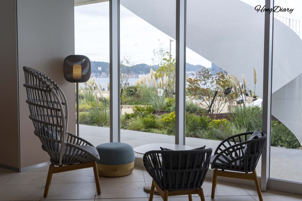 Zona de asientos del lobby de RISONARE Shimonoseki con vista a Fugu Beach y el Estrecho de Kanmon a través del ventanal