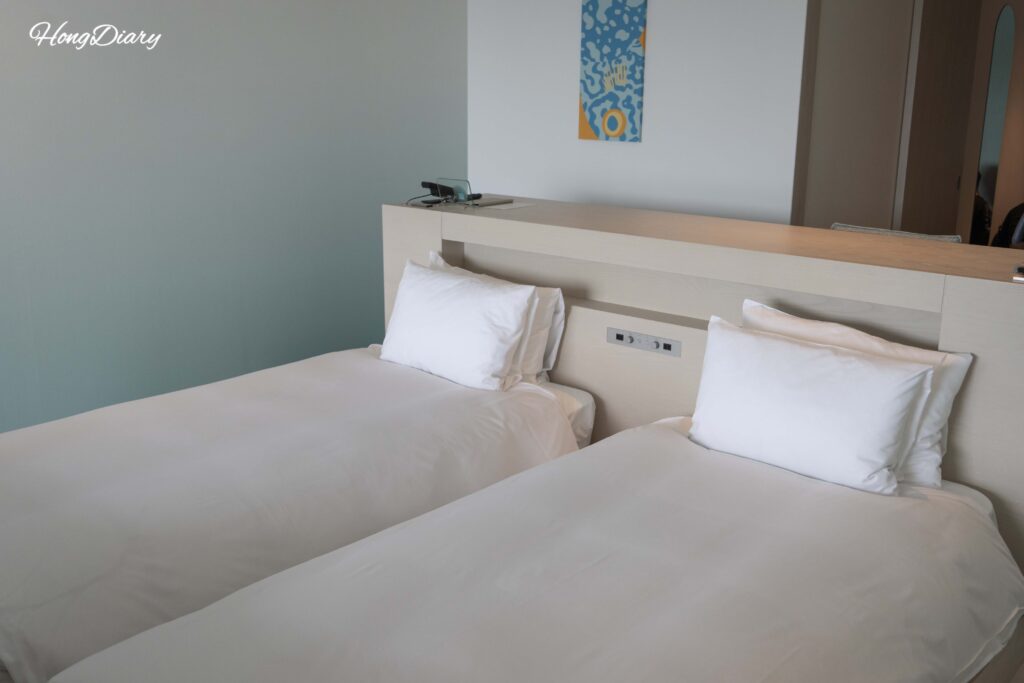 Low-profile plush bed in a Deluxe Quad room at RISONARE Shimonoseki, designed for safe sleeping for young children