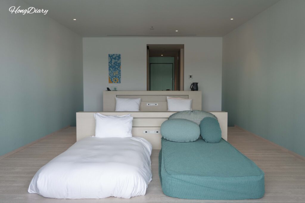 Camas, mesa y sofá cama de RISONARE Shimonoseki vistos desde el lado de la ventana