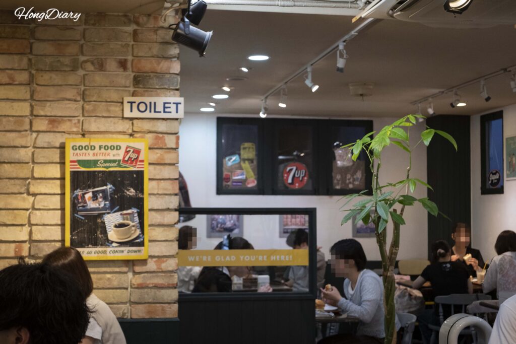 Interior dining area of Sandwich Factory OCM in Kitakyushu filled with customers enjoying sandwiches at small tables