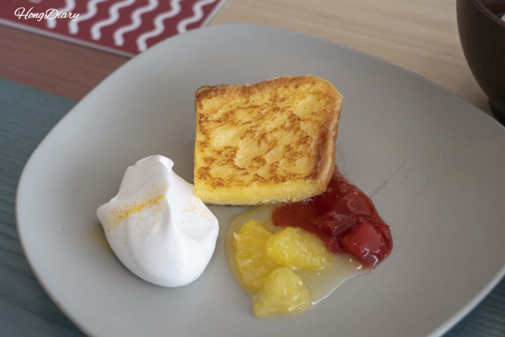 Primer plano de tostada francesa con crema batida en el desayuno de PUKU PUKU